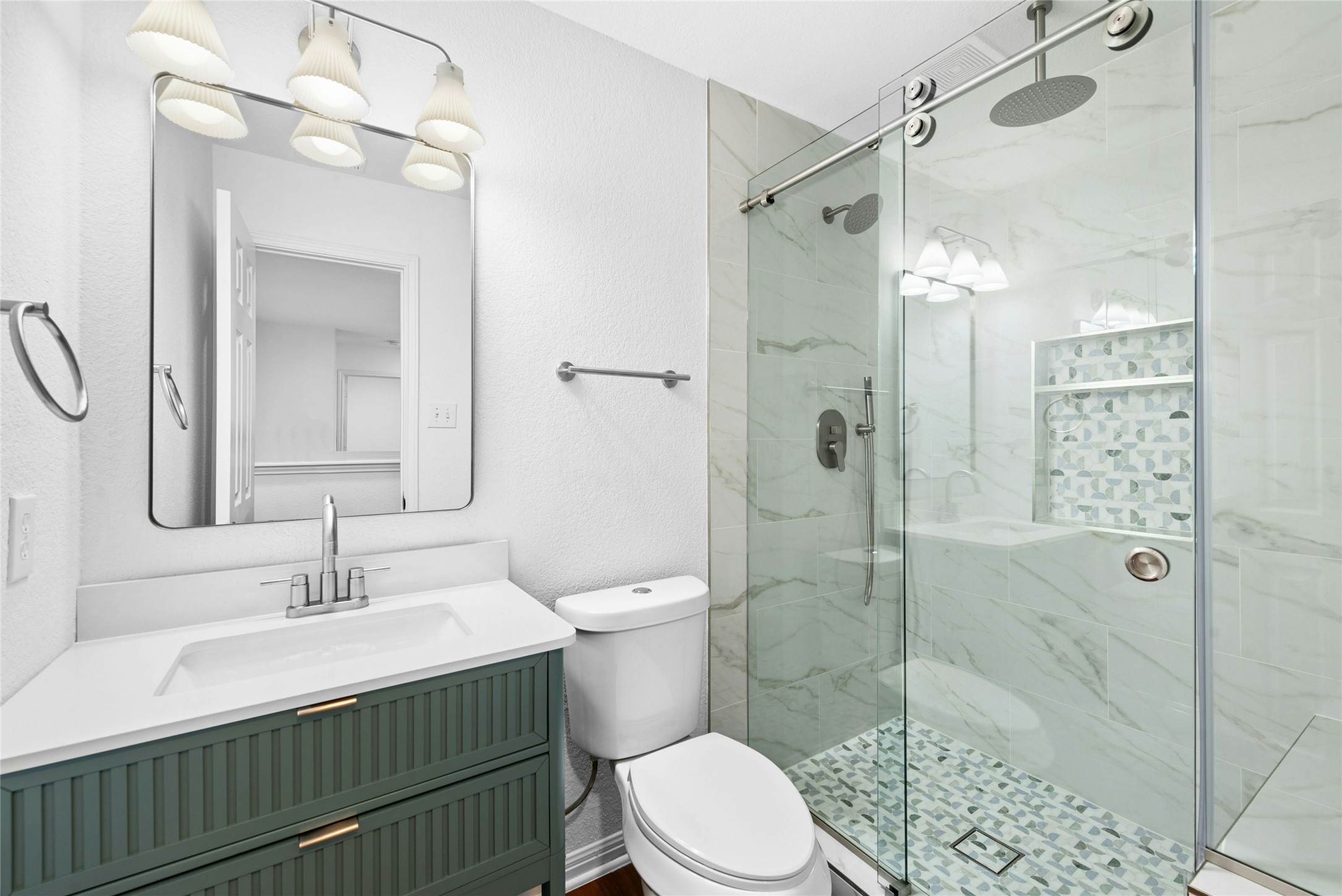 813 Caribou Ridge Trail Pflugerville, TX 78660 - Photo 35 of 39 Fully renovated upstairs bathroom with walk-in glass shower, marble tile walls, designer mosaic niche, and modern vanity.
