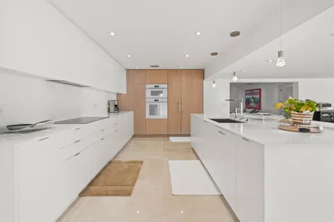 a large white kitchen with a large window