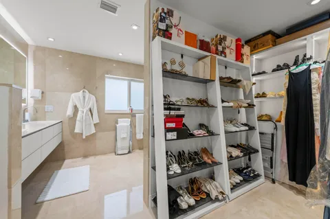 a view of walk in closet with clothes and shoes