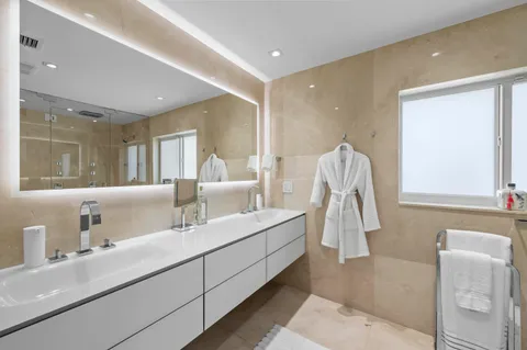 a en suite bathroom with double vanity and a mirror