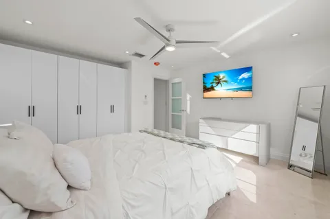 a spacious bedroom with a bed and a painting on the wall