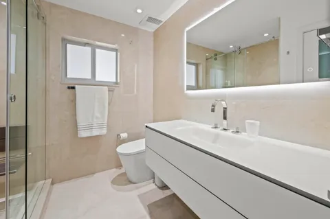 a bathroom with a toilet sink and mirror