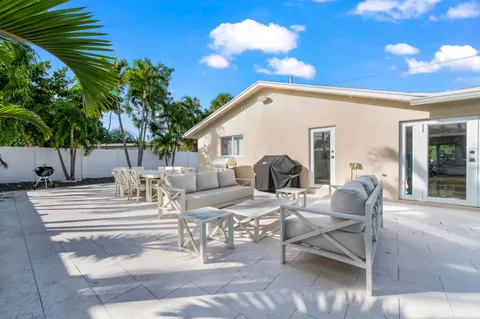 a view of a patio with dining table and chairs with plants and wooden fence