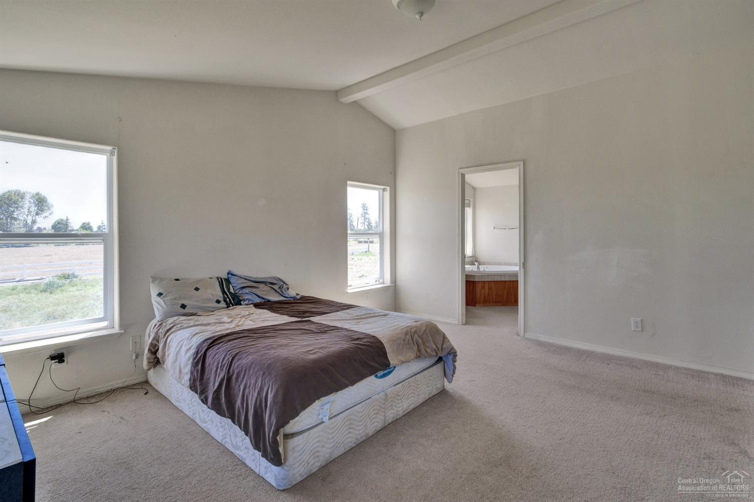 67252 Gist Road Bend, OR 97703 - Photo 12 of 24 a spacious bedroom with a bed and window