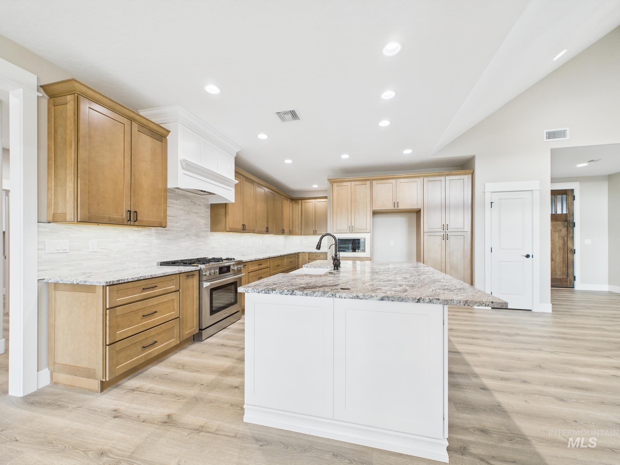 1910 Ruth Lane Emmett, ID 83617 - Photo 14 of 42 Kitchen with high end stainless steel range oven, light stone counters, light wood finished floors, recessed lighting, and a kitchen island with sink
