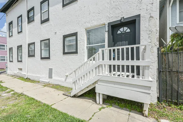 a view of a house with a small yard and wooden fence
