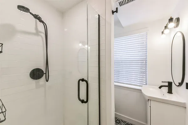a bathroom with a sink a mirror and shower