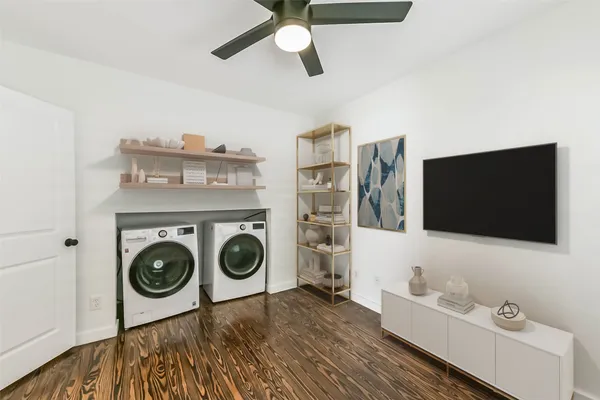 a bathroom with a washing machine and a flat screen tv