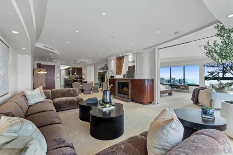 a living room with furniture kitchen view and a large window