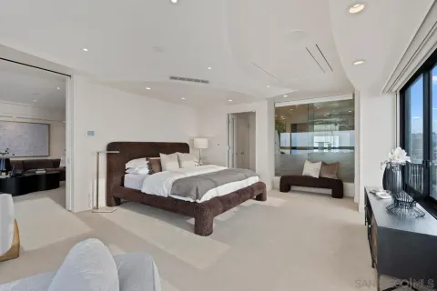 a spacious bedroom with a bed and large mirror in a room