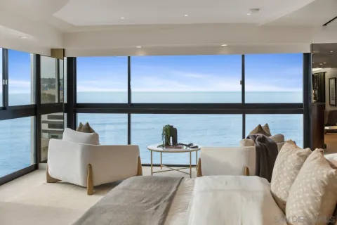 a living room with couches lamp and large window with outdoor view