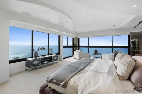 a bedroom with a bed and large windows