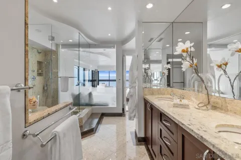a bathroom with a granite countertop sink mirror and shower