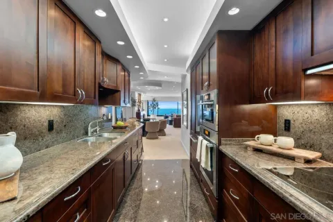 a kitchen with granite countertop kitchen island stainless steel appliances a sink stove top oven and cabinets