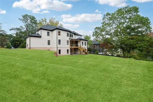 a view of a house with a big yard and large trees