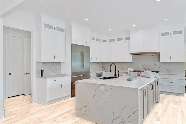 a kitchen with a sink a stove a refrigerator and white cabinets
