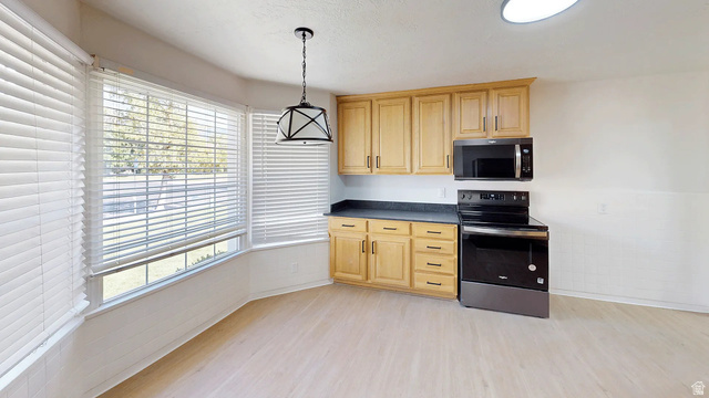 1115 North Main Street Bountiful, UT 84010 - Photo 12 of 17 Kitchen area with light wood-finish cabinetry, dark countertops, and black appliances