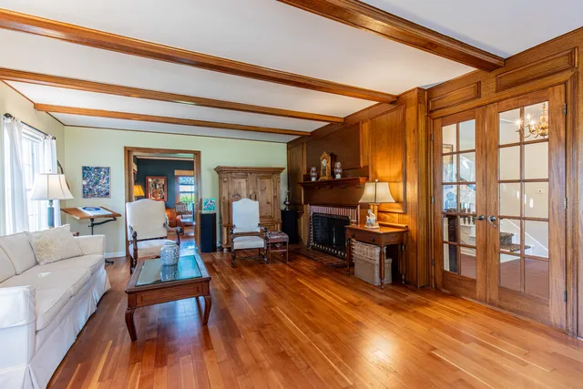 a view of a hallway with wooden floor and windows