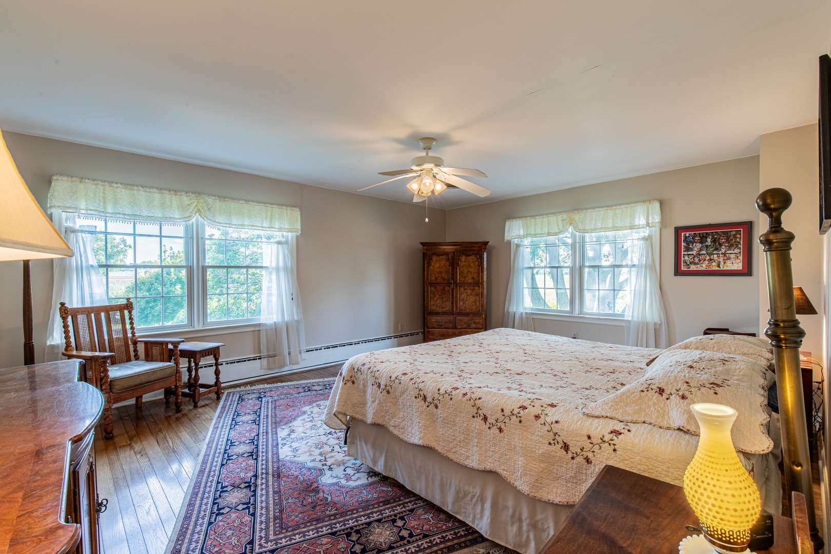 1840 South Main Street Princeton, IL 61356 - Photo 24 of 51 a spacious bedroom with a balcony a bed a couch and a large window with wooden floor