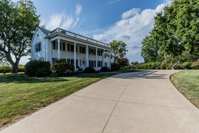 a front view of a house with a yard and trees