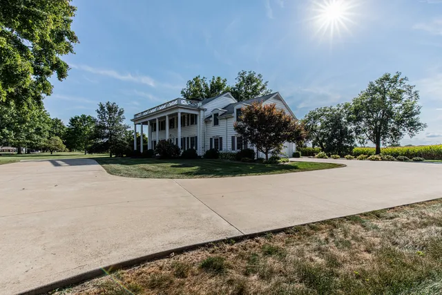 a front view of a house with a yard and trees