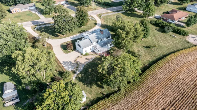 an aerial view of a house with a yard and lake view