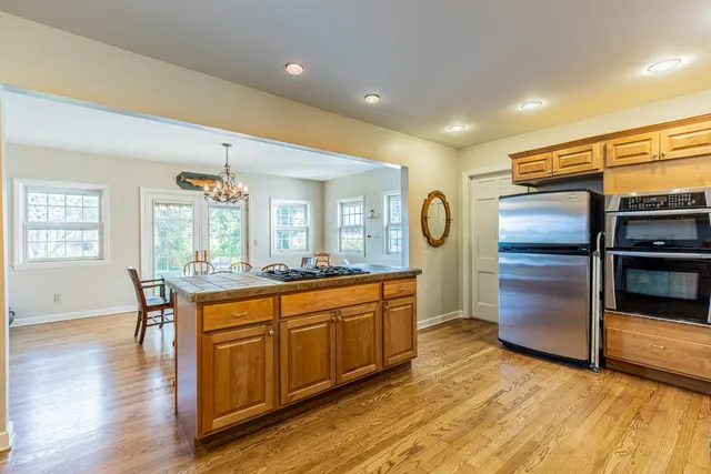 a kitchen with stainless steel appliances granite countertop a refrigerator and a stove top oven