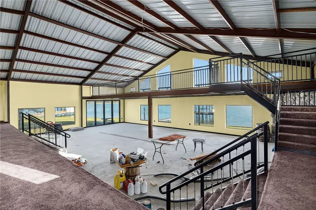 a view of a roof deck with table and chairs under an umbrella with wooden floor