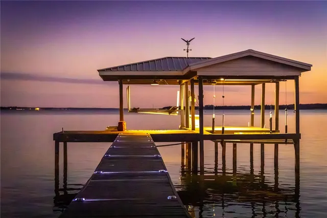 a view of a lake with a floor to ceiling window and wooden floor