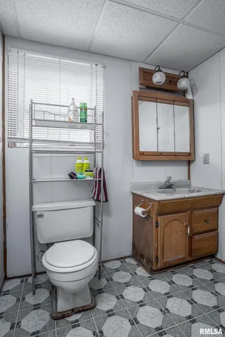 a bathroom with a granite countertop toilet sink and mirror