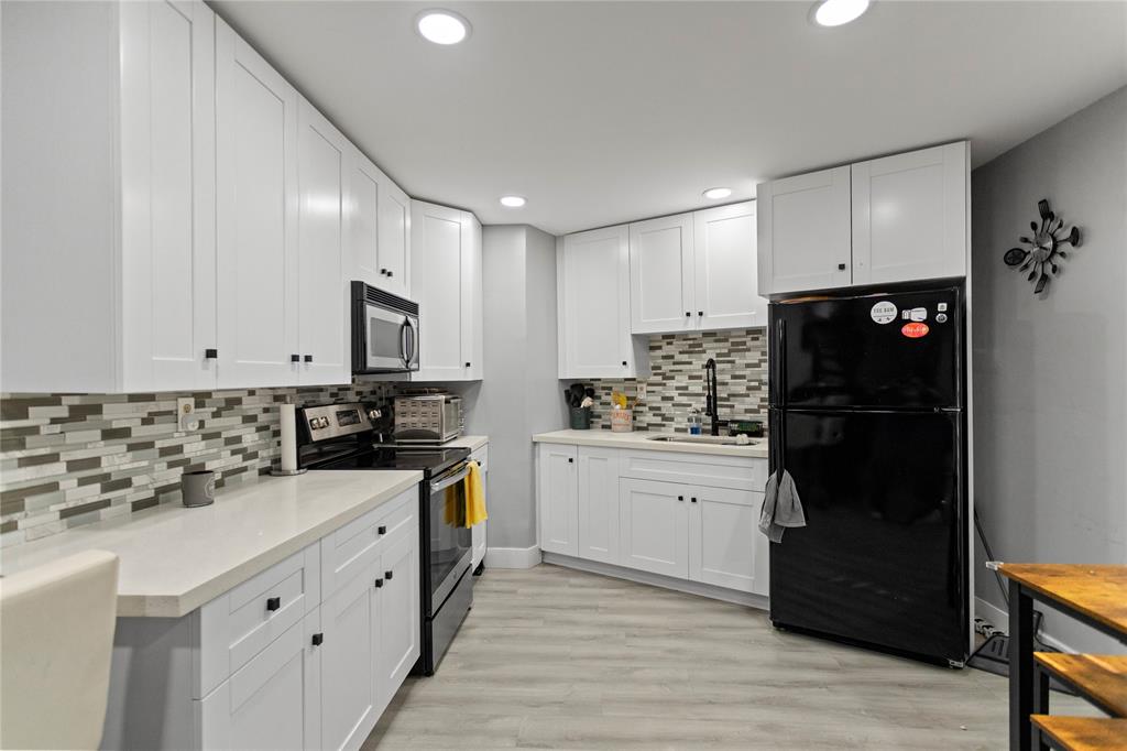 a kitchen with granite countertop white cabinets and stainless steel appliances