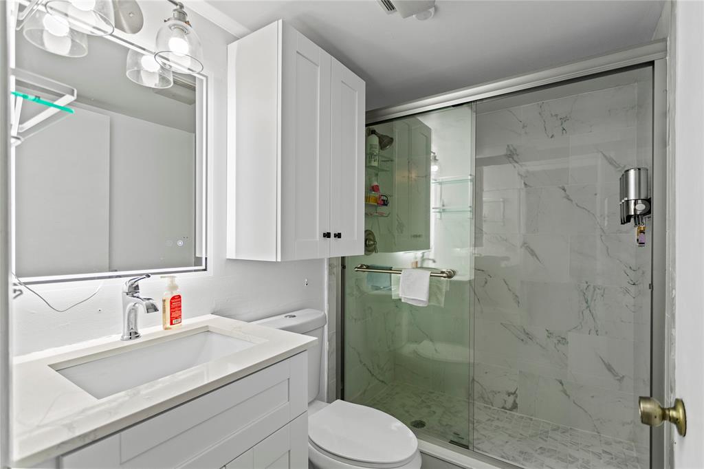 22940 Oxford Place, Unit C Boca Raton, FL 33433 - Photo 17 of 60 a bathroom with a sink vanity granite toilet and shower