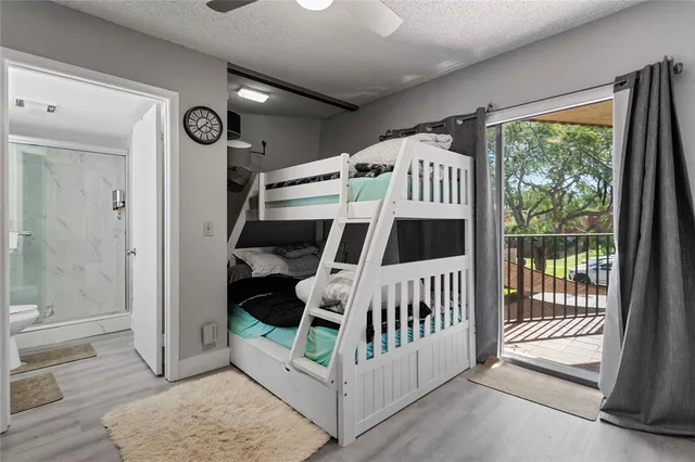 a bedroom with a bed couch chandelier and a window