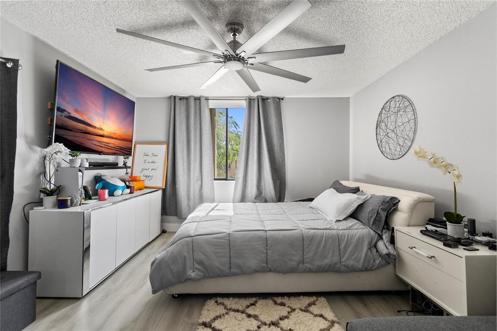 22940 Oxford Place, Unit C Boca Raton, FL 33433 - Photo 23 of 60 a bedroom with a bed and a flat screen tv