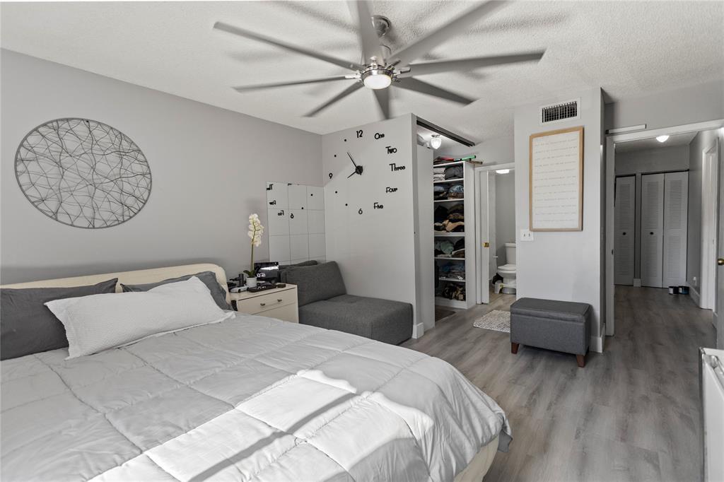 22940 Oxford Place, Unit C Boca Raton, FL 33433 - Photo 25 of 60 a bedroom with a bed and a chandelier