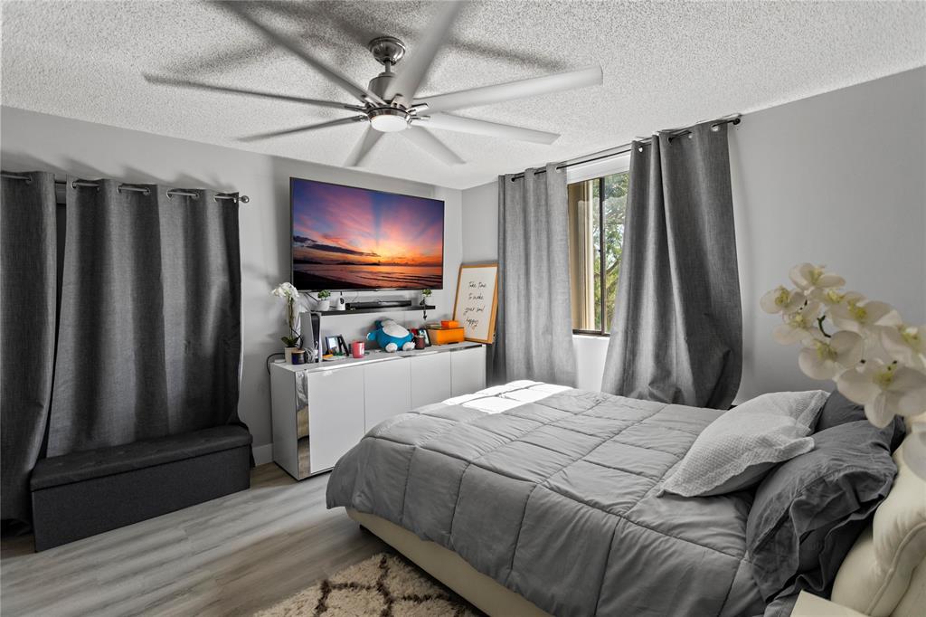 22940 Oxford Place, Unit C Boca Raton, FL 33433 - Photo 27 of 60 a bedroom with a bed and a flat screen tv