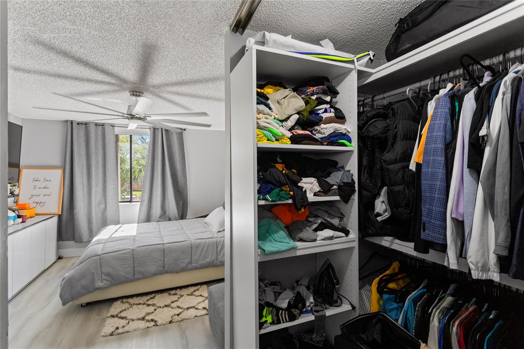 22940 Oxford Place, Unit C Boca Raton, FL 33433 - Photo 29 of 60 a view of walk in closet with clothes and shoes