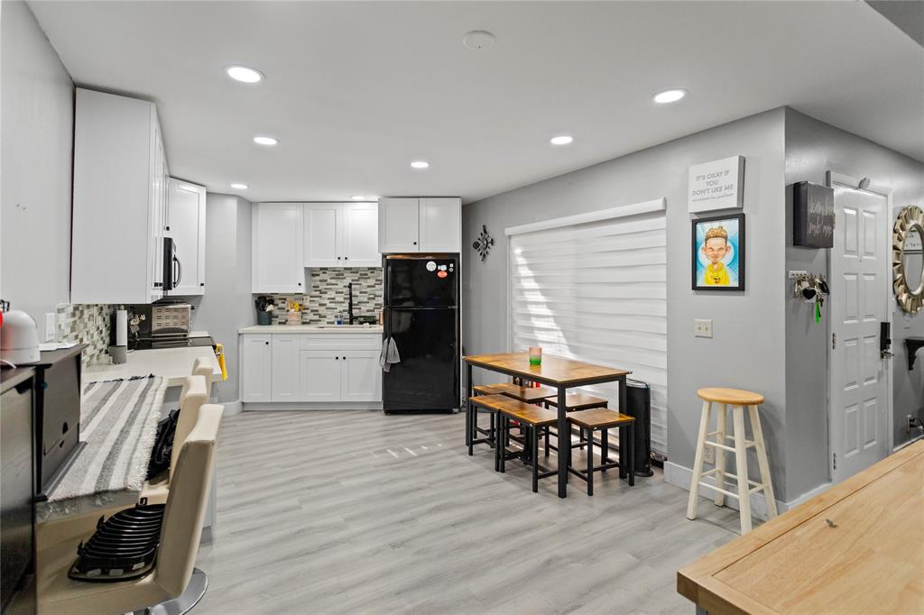 22940 Oxford Place, Unit C Boca Raton, FL 33433 - Photo 3 of 60 a kitchen with stainless steel appliances dining table chairs and wooden floor