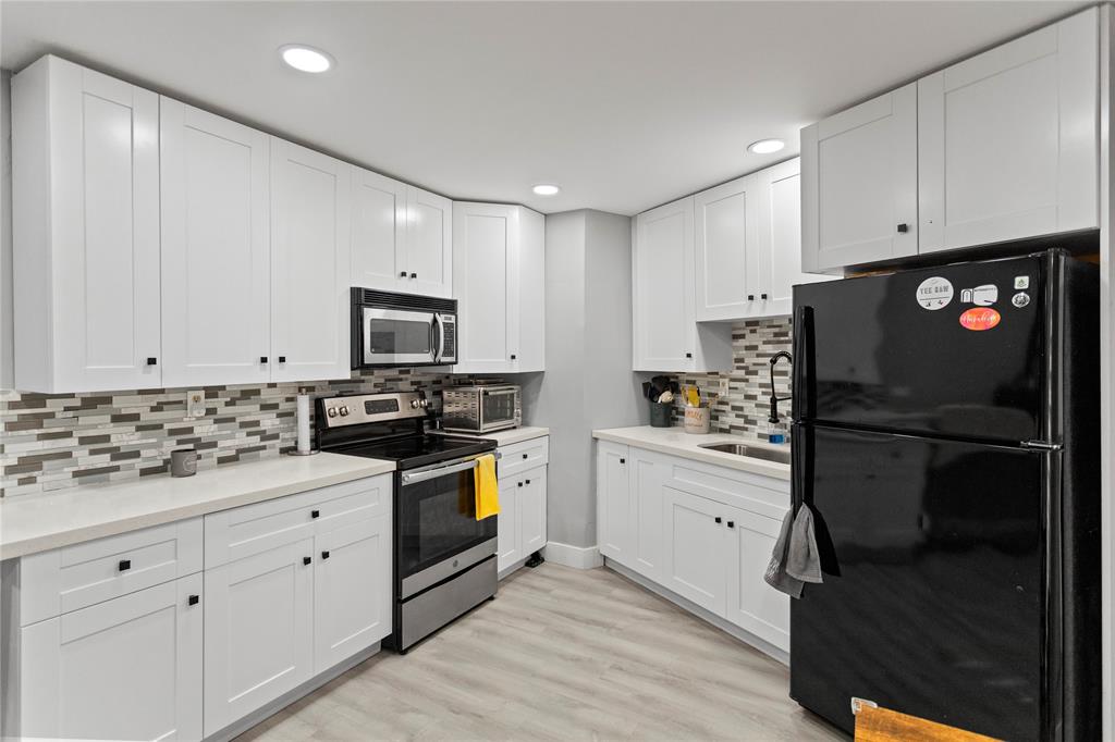 22940 Oxford Place, Unit C Boca Raton, FL 33433 - Photo 4 of 60 a kitchen with white cabinets and stainless steel appliances