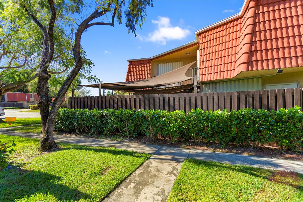 22940 Oxford Place, Unit C Boca Raton, FL 33433 - Photo 53 of 60 a view of a swimming pool with a patio and a garden