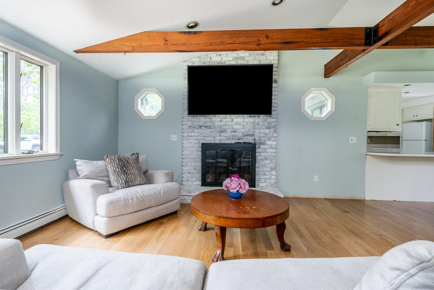 115 Pine Needle Road Wellfleet, MA 02667 - Photo 7 of 37 a living room with furniture a flat screen tv and a fireplace