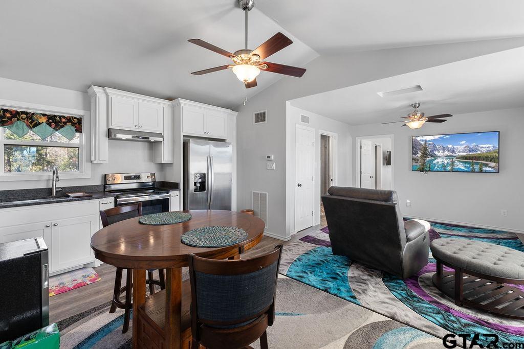 1102 Lilly Lane Bullard, TX 75757 - Photo 23 of 48 a kitchen with stainless steel appliances granite countertop a stove a refrigerator a sink a dining table and chairs with wooden floor