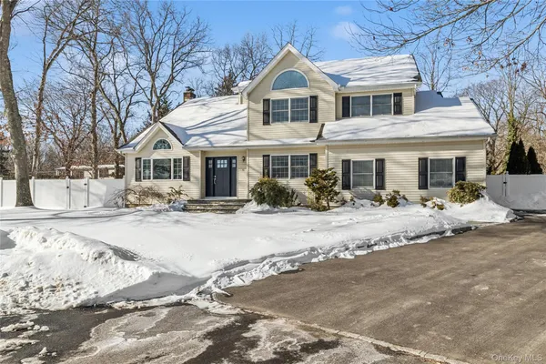 a front view of a house with a yard covered in snow