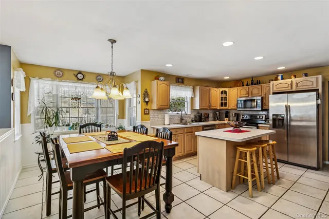 a kitchen with a dining table chairs and refrigerator