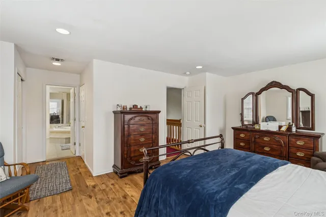 a spacious bedroom with a bed and wooden floor