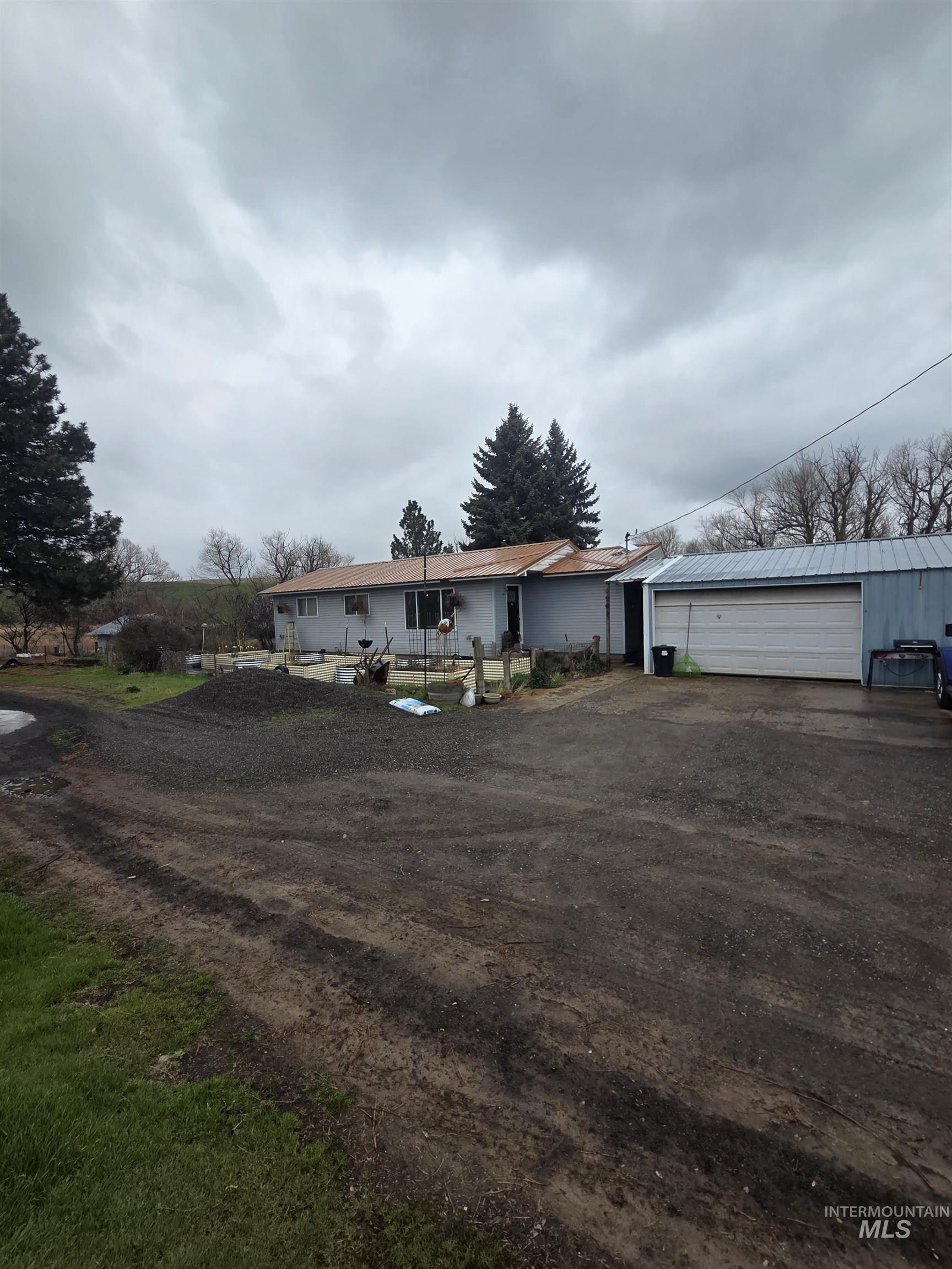 Back of house featuring a garage and driveway