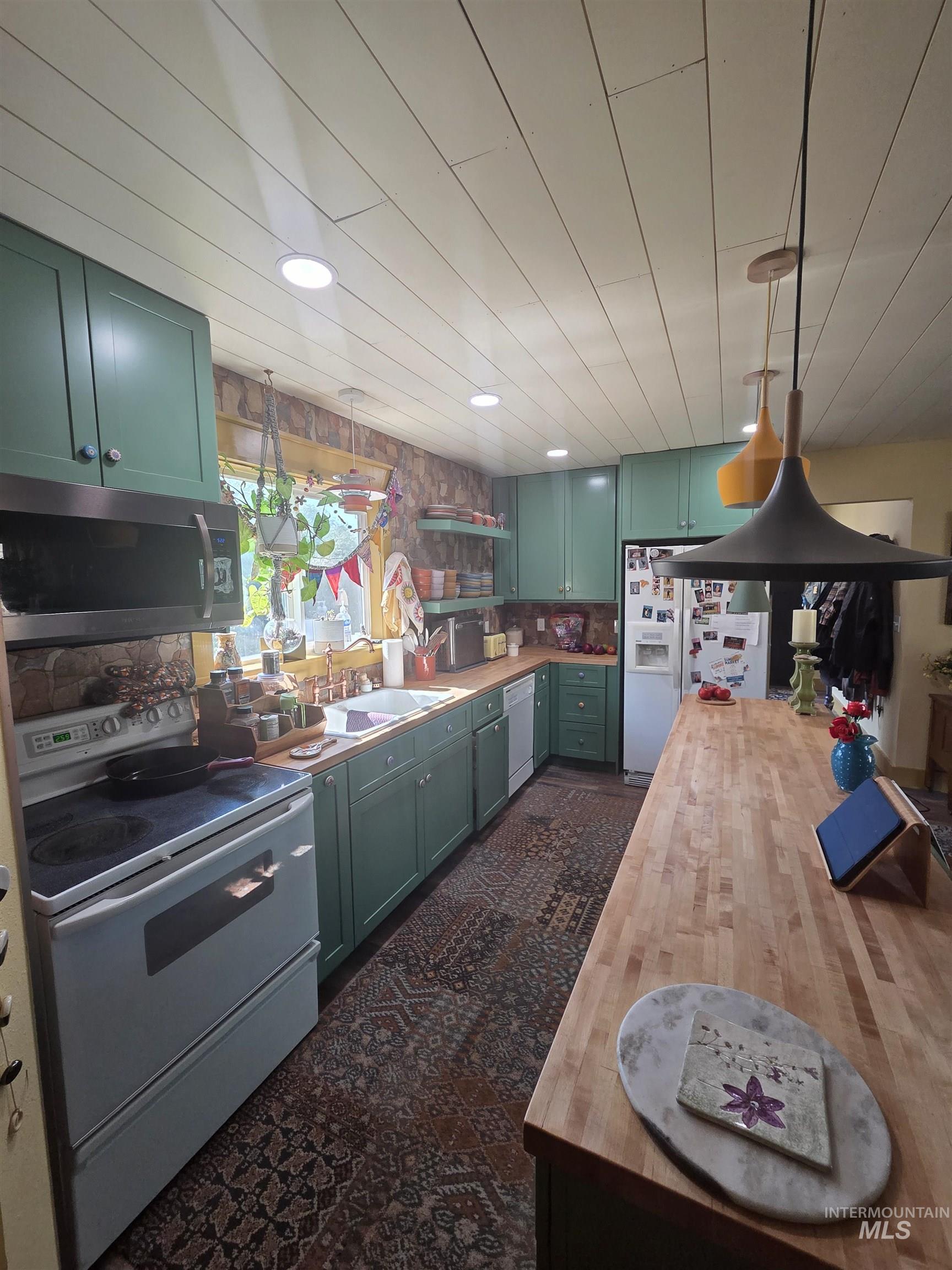 870 Dutch Flat Road Pomeroy, WA 99347 - Photo 15 of 33 Kitchen featuring green cabinets, butcher block counters, white appliances, decorative light fixtures, and recessed lighting