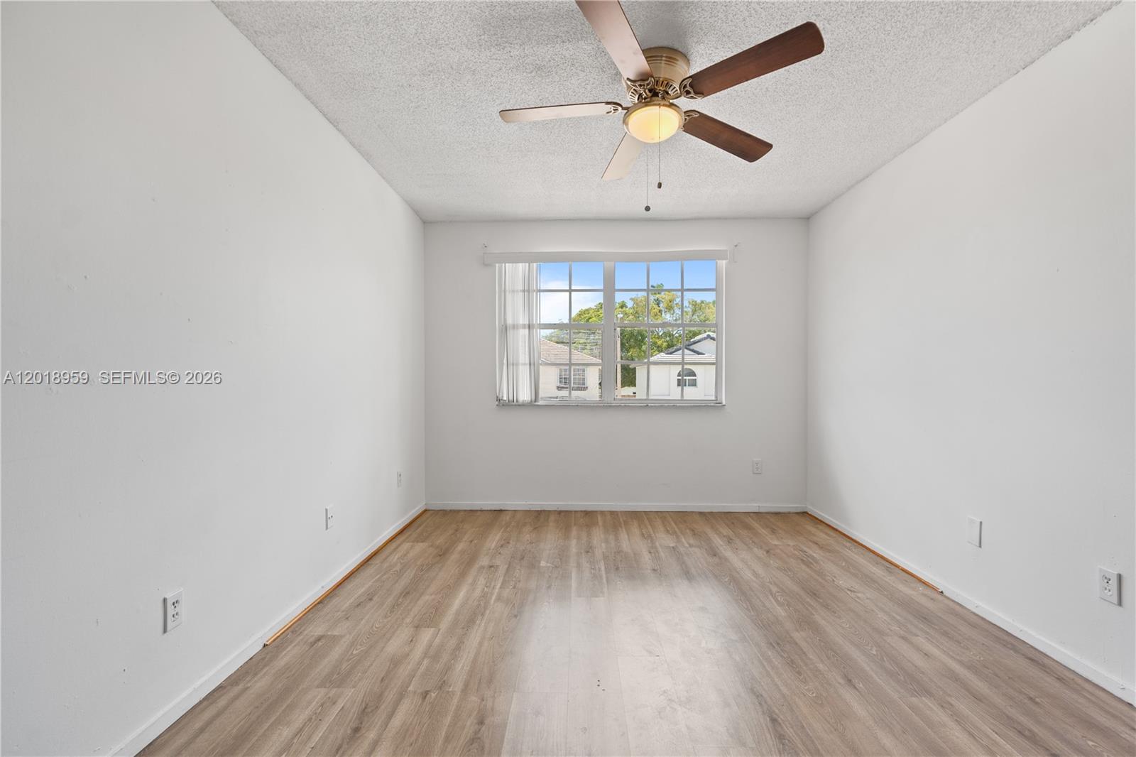 15345 Southwest 63rd Terrace Miami, FL 33193 - Photo 27 of 51 an empty room with wooden floor chandelier fan and windows