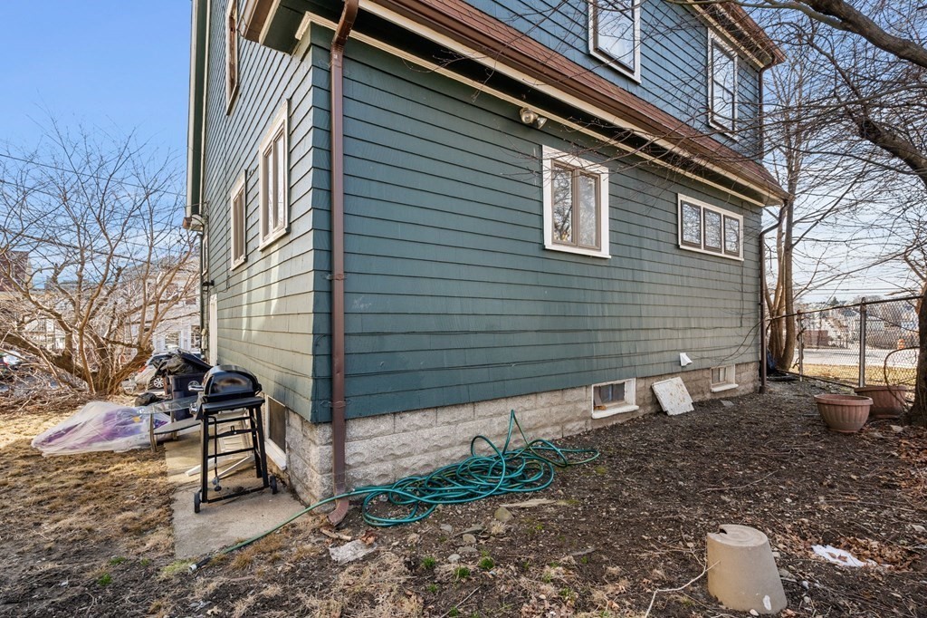 29 Harding Avenue Everett, MA 02149 - Photo 27 of 32 a view of a backyard with a chair and table and chairs and wooden fence