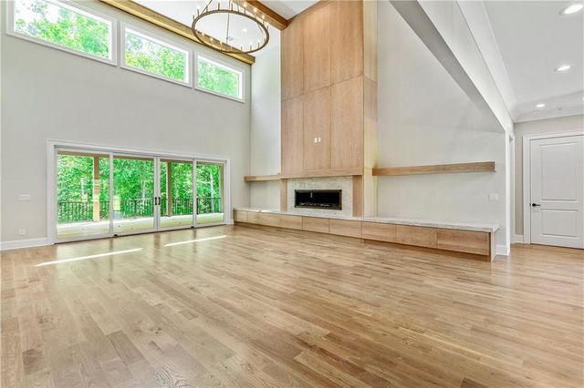 a view of a room with wooden floor chandelier and windows